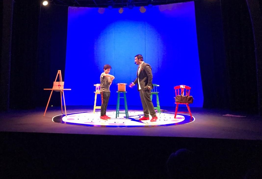 Javier Natera en el escenario con una participante del público
