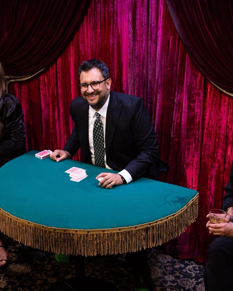 Javier Natera performing close-up card magic at a table: trade show booth entertainment in Mexico